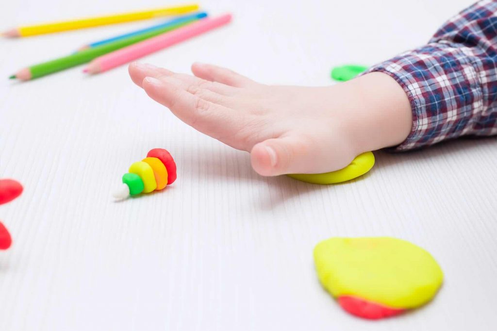 Child busy playing with plasticine